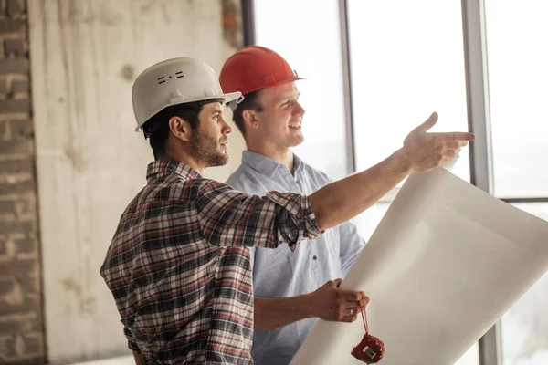 Arbetstagare visar utvecklingen av byggandet till en chef — Stockfoto