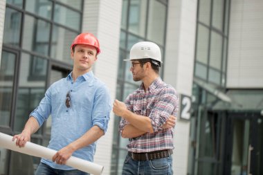 Başarılı genç inşaatçı dışarıda patronunu dinliyor.