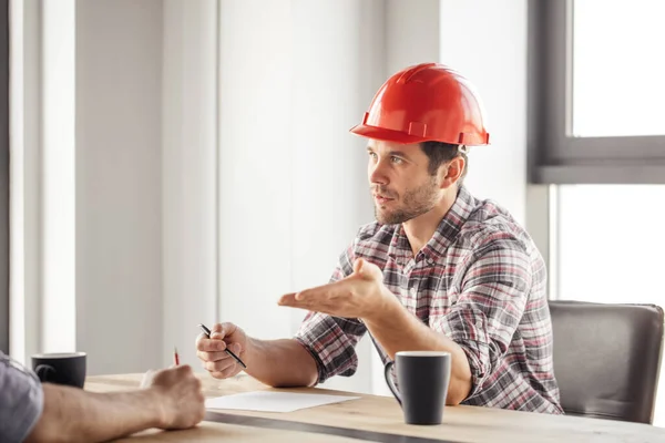 Schöner Ingenieur mit rotem Hut bietet einem Mann den Job an — Stockfoto