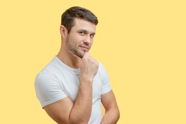 Çenesinde eli olan çekici beyaz bir adam.