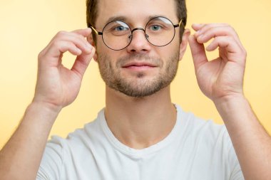 Hoş bir adam yeni yuvarlak gözlükler deniyor.