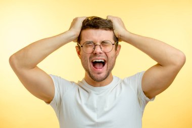 Bağıran sinirli adam saçlarını yoluyor.