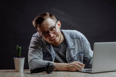 Gülümseyen genç programcı şık kıyafetler giyiyor.