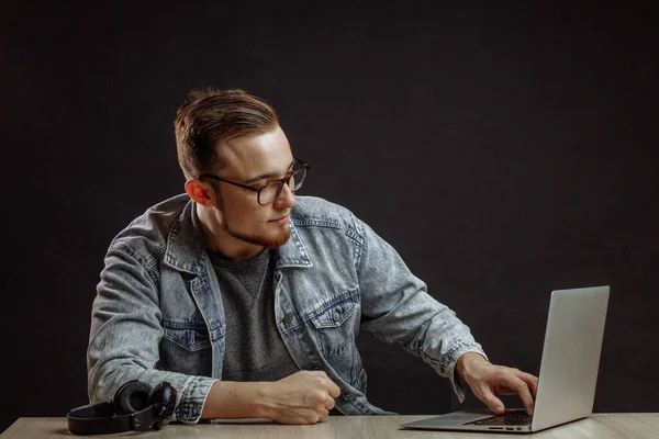 Jong mannetje in stijlvolle outfit op zoek naar de laptop — Stockfoto