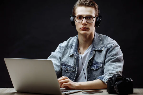 Kalme jonge collega in casual kleding zitten aan het bureau — Stockfoto