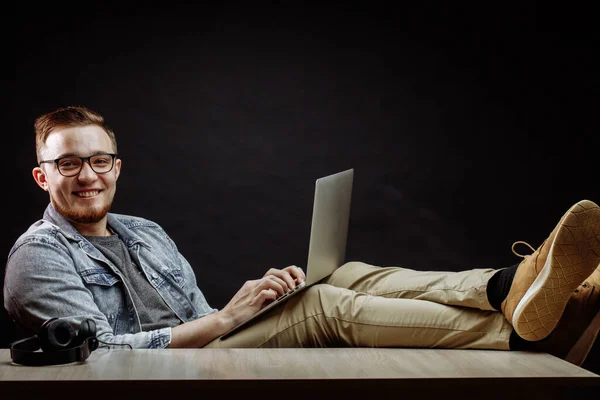 Gelukkige zakenman met behulp van het Net op het werk en zitten met gekruiste benen — Stockfoto