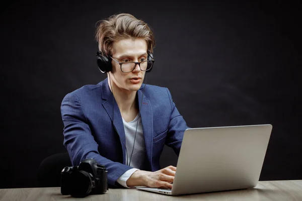 Verraste fotograaf in blauw pak zittend — Stockfoto