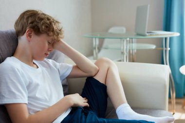 Uykucu çocuk, evdeki kanepeye otur.