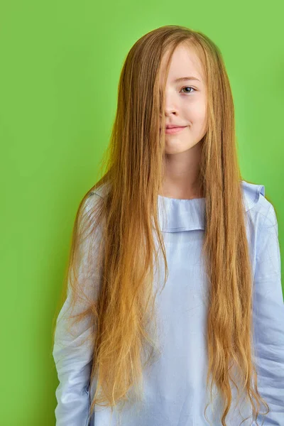 초록색 배경에 긴 머리를 가진 귀엽고 작은 원추리 소녀 — 스톡 사진