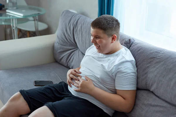 Fat young boy watch tv and laugh — Stock Photo, Image