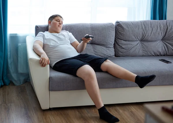 Niño perezoso sentarse a ver la televisión en casa — Foto de Stock