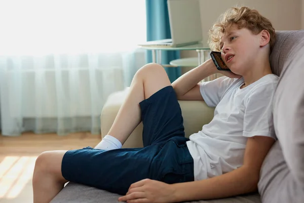 Niño niño se sienta a hablar por teléfono con mamá — Foto de Stock