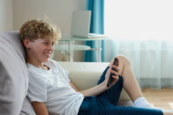 Guapo adolescente chico hablar por teléfono en línea — Foto de Stock
