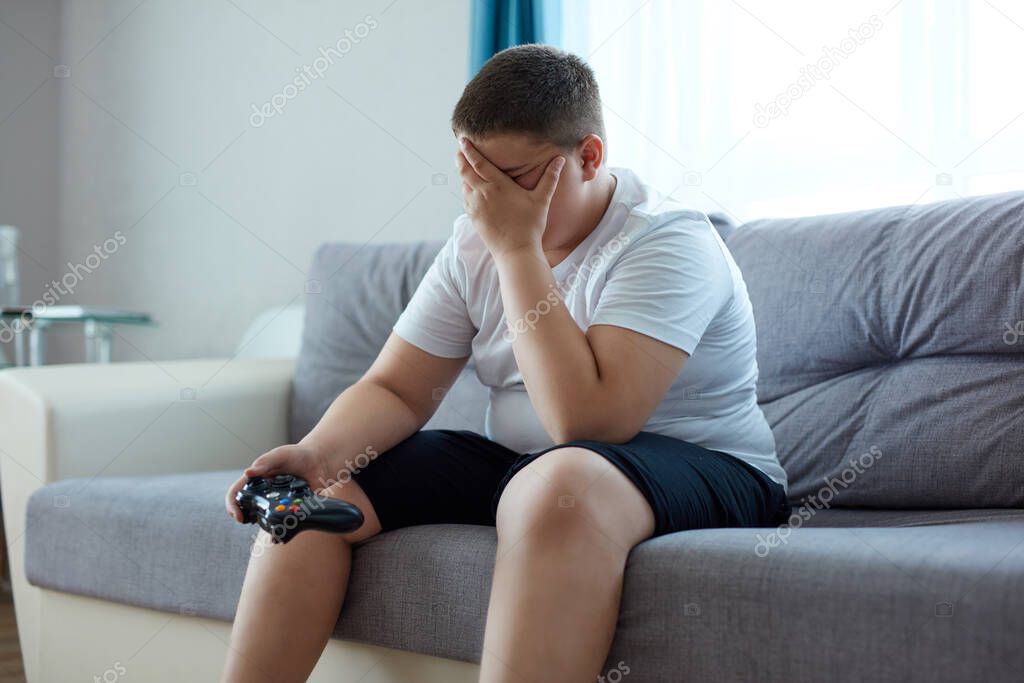 sad fat boy is upset after losing a video game