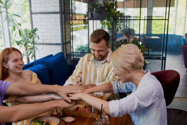 Meslektaşlar restoranda el ele tutuşuyor.