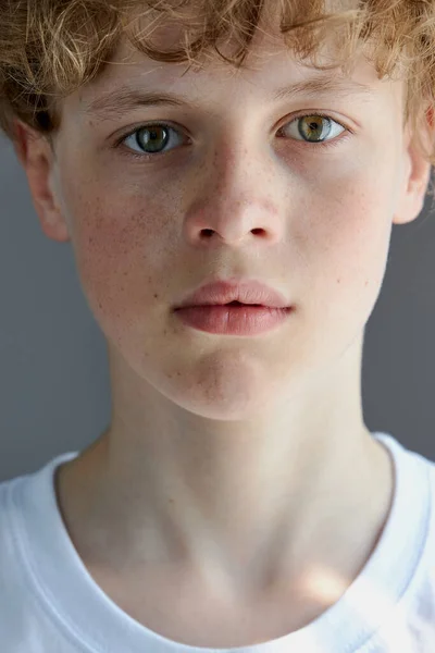 portrait of curly redhead freckled boy