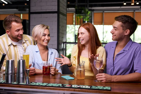 Pelirroja contar historias a amigos en el bar — Foto de Stock