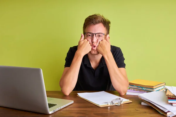 Jovem caucasiano cansado do trabalho, na mesa de escritório — Fotografia de Stock