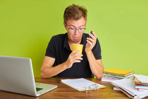 Meglepett férfi néz üres csésze kávét, miközben ül a munkahelyen — Stock Fotó