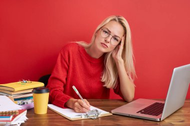 Genç, güzel, üzgün ve bunalımlı Kafkasyalı yönetici ofis bilgisayarında stres içinde çalışıyor.