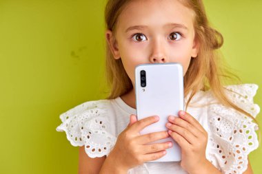 Akıllı telefonlu şirin küçük bir kızın portresi.