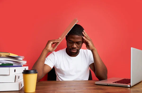 Молодой напряженный африканский мужчина работает с компьютером ноутбук в отчаянии, депрессии — стоковое фото