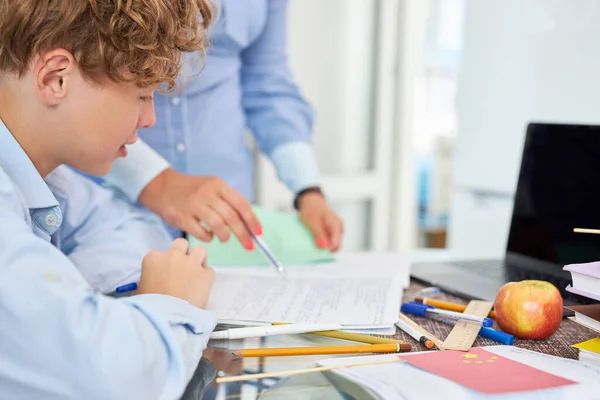 Joven profesora mujer ayudar adolescente chico a hacer tarea — Foto de Stock