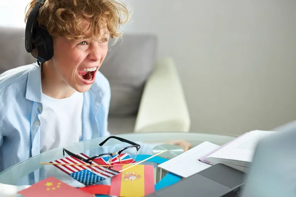 学校の少年はノートパソコンを見て叫びゲームをして — ストック写真