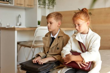 Yorgun çocuklar otelde taksi bekliyor.