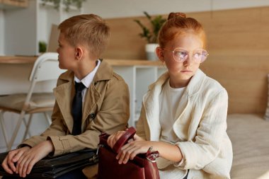 Kızlarla oğlanlar yataklarında paltoyla otururlar.