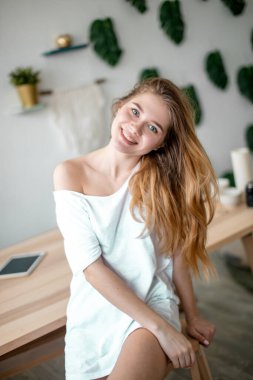 Yeşil gözlü, sıradan giyinmiş mutlu bir öğrenci.