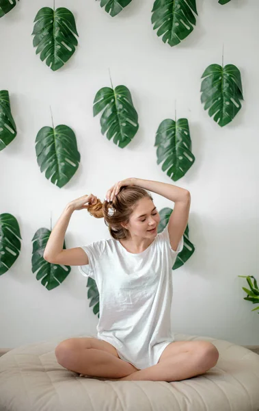 Jeune fille attrayante est la réparation de ses cheveux. femme fait coiffure — Photo