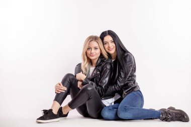 Aile değerleri. İki bayan rockçı yerde oturuyor ve kameraya poz veriyorlar.