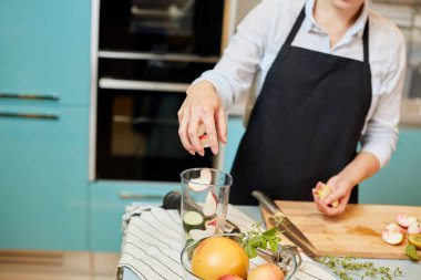 Genç bayan meyve suyu yapacak.