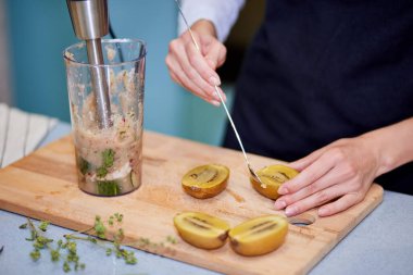 Yetenekli şef meyve suyu için kivi hazırlıyor.