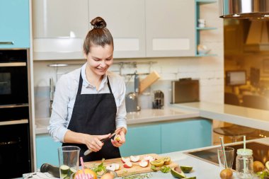 Neşeli genç bayan yemek pişirmede iyidir.