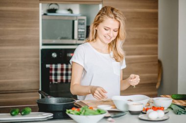 Neşeli kadın lezzetli bir yemek yapıyor.