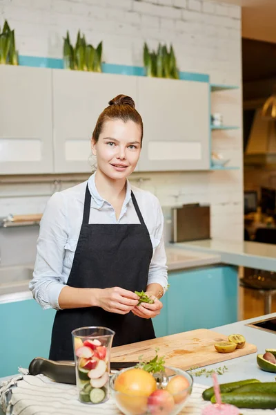 Talentierte attraktive Köchin hält grün und posiert für die Kamera — Stockfoto