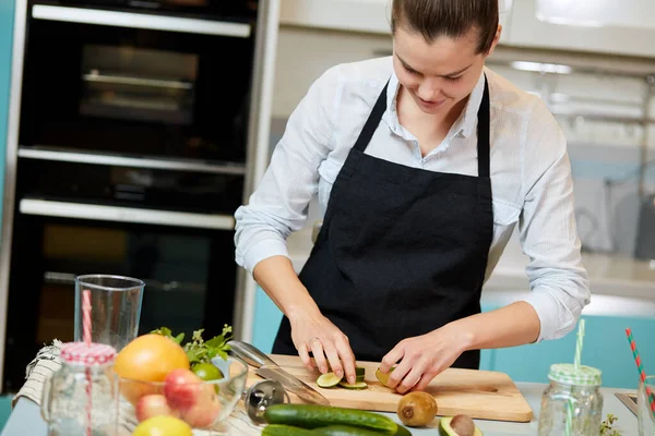 Mujer creativa chef ha cortado pepinos para la ensalada — Foto de Stock