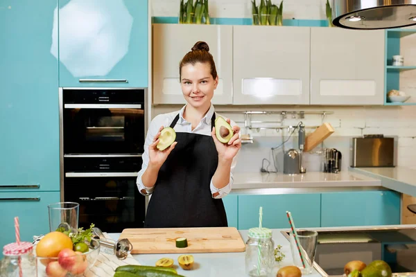 Attractive gorgeous chef with avocadoes posing to the camera — Stock Photo, Image