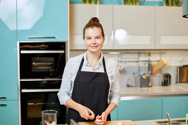 Glückliche junge Frau wird eine Limonade in der Küche zubereiten — Stockfoto