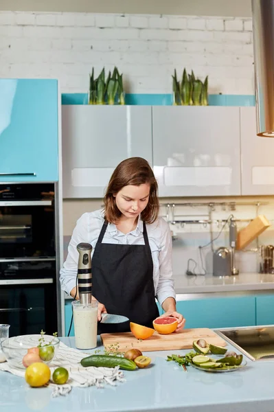 Gyönyörű komoly lány vágás grapefruit — Stock Fotó