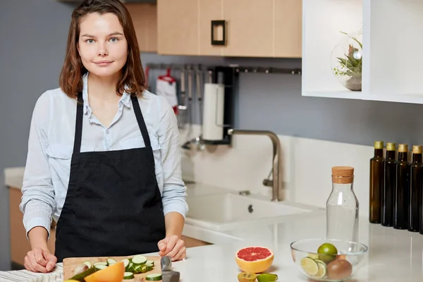 Agréable jeune chef est debout à la table et va cuisiner quelque chose de savoureux — Photo