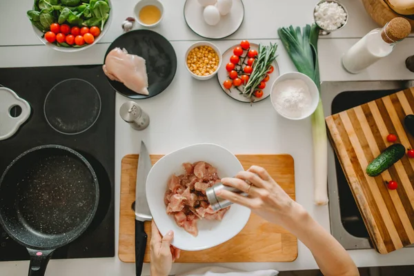 Female cook salting meat on the plate. top view — Stock Image Female cook salting meat on the plate. top view Stock Image