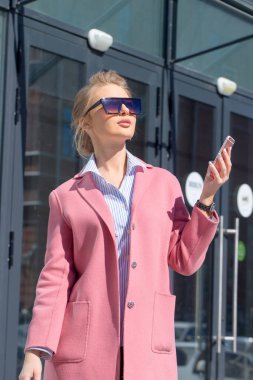 Arka planında modern binalar olan zarif bir kadın.