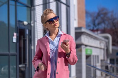 Kameraya poz veren güneş gözlüklü çekici bir kadın.