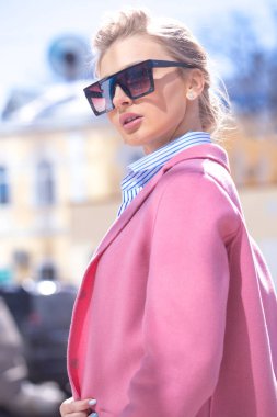 Şık güneş gözlüklü güzel sarışın bir kadının moda fotoğrafı..