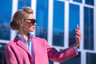 Havalı bir kızın selfie çekerken yan görünüm portresini kapat.