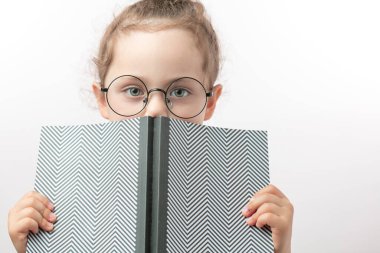 Yeşil gözlü güzel kız kitap okuyormuş gibi yapıyor.
