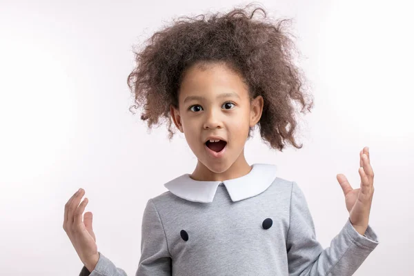 Rolig afro flicka är förvånad eftersom hon har en ovanlig frisyr — Stockfoto